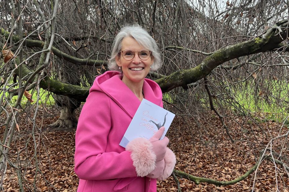 Dr. Katrien Jacobi mit ihrem Buch vor einem Baum